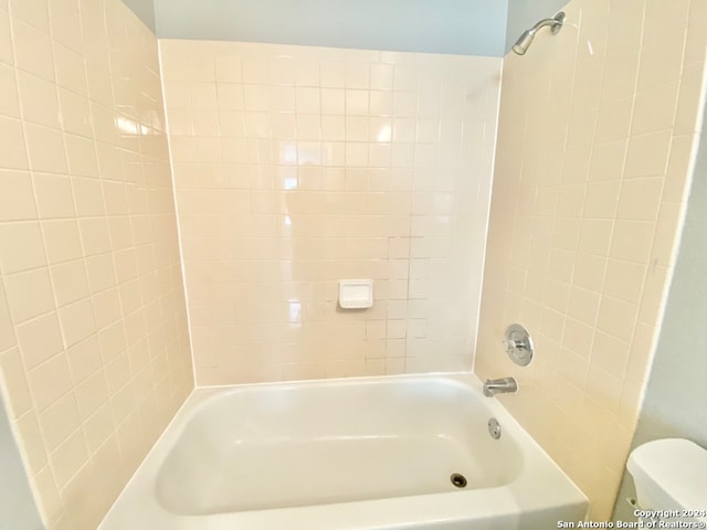 bathroom with tiled shower / bath and toilet