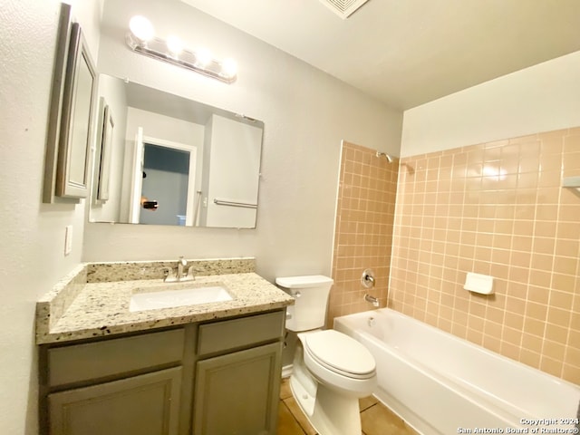 full bathroom featuring toilet, tiled shower / bath, vanity, and tile patterned floors