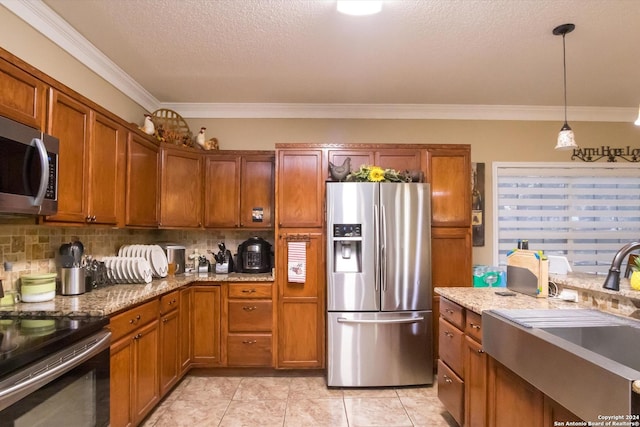 kitchen with stainless steel appliances, a sink, hanging light fixtures, backsplash, and brown cabinetry