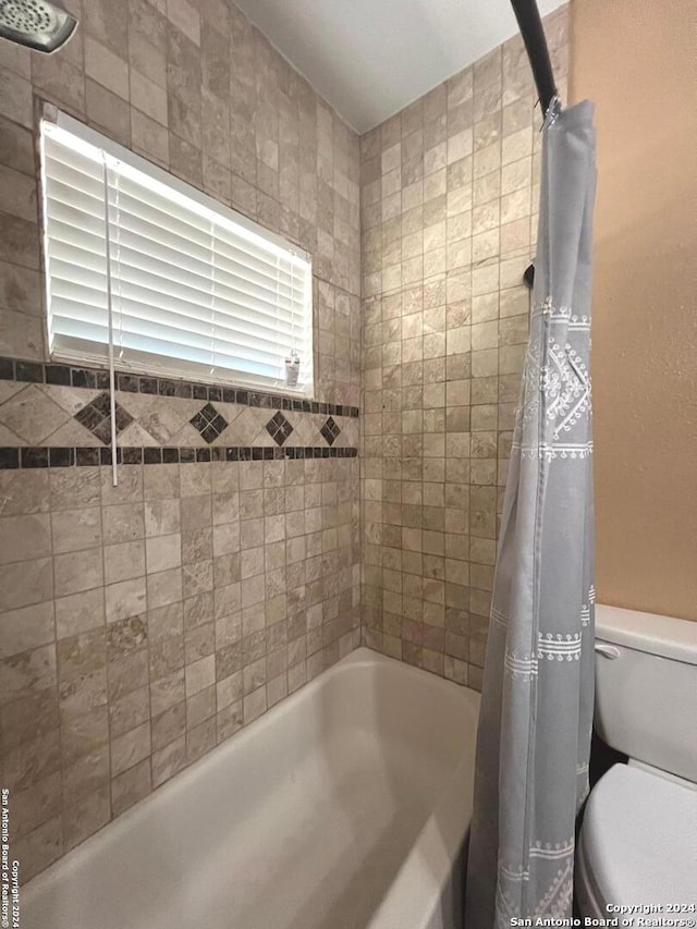 bathroom with shower / tub combo and toilet