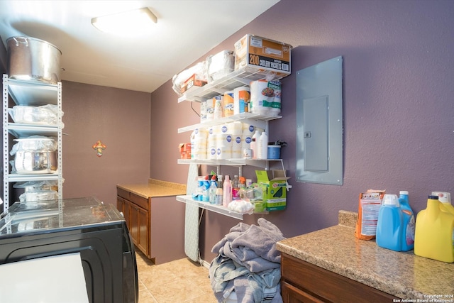 laundry area with laundry area, electric panel, independent washer and dryer, and light tile patterned floors