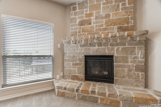 details featuring a stone fireplace and carpet floors