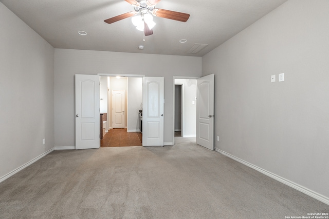 unfurnished bedroom featuring light colored carpet and ceiling fan