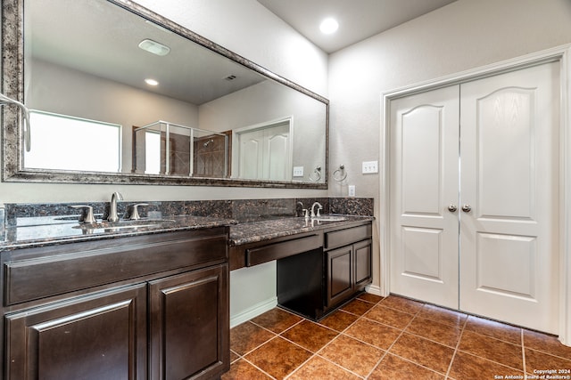 bathroom featuring vanity, walk in shower, and tile patterned flooring