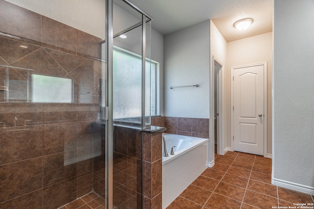 bathroom with tile patterned floors, shower with separate bathtub, and a textured ceiling