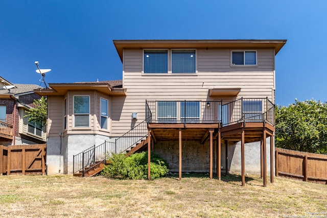 back of house featuring a deck and a lawn