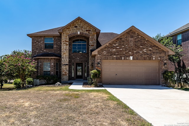 view of property featuring a garage and a front lawn