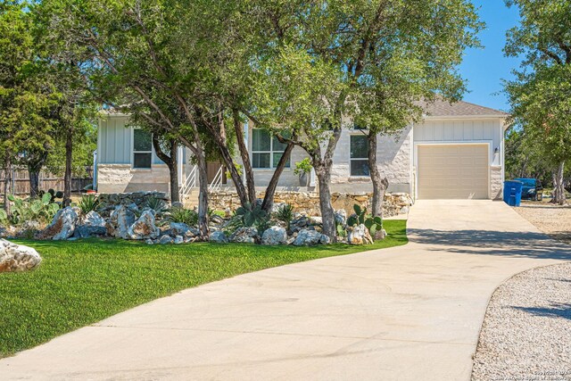 obstructed view of property featuring a garage and a front lawn