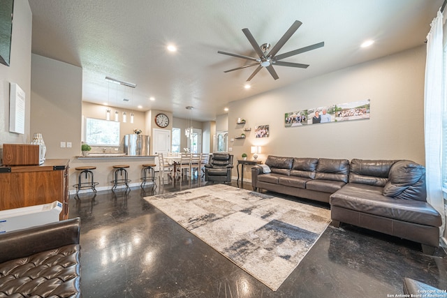 living room with ceiling fan and a textured ceiling