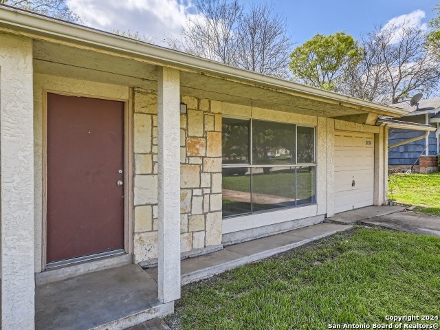 view of exterior entry with a yard