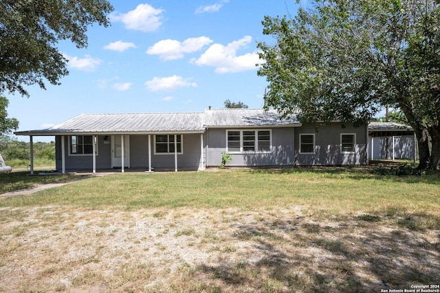 ranch-style home featuring a front lawn and metal roof