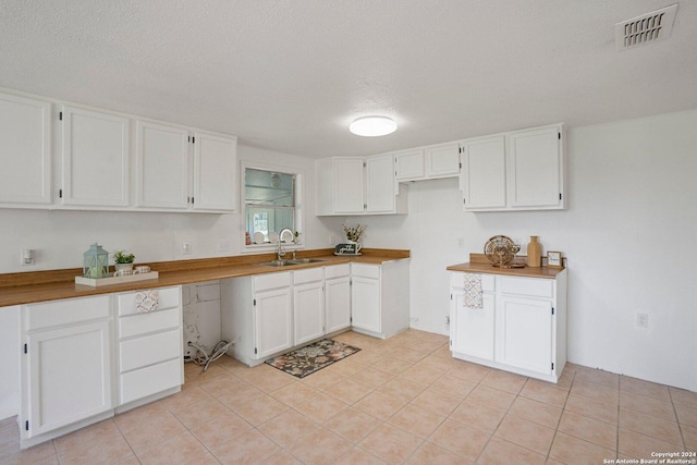 kitchen featuring a sink, visible vents, and white cabinets