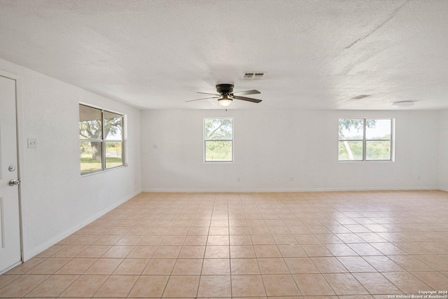 unfurnished room featuring visible vents, a textured ceiling, a healthy amount of sunlight, and ceiling fan