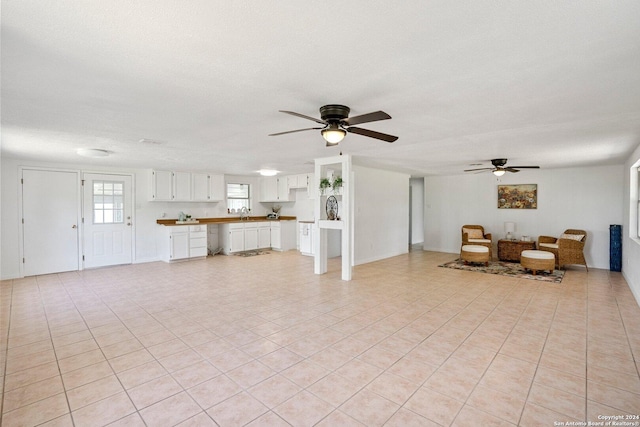 unfurnished living room with a textured ceiling, a ceiling fan, and a sink