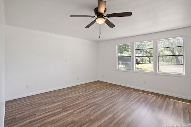 empty room featuring a ceiling fan, wood finished floors, and baseboards