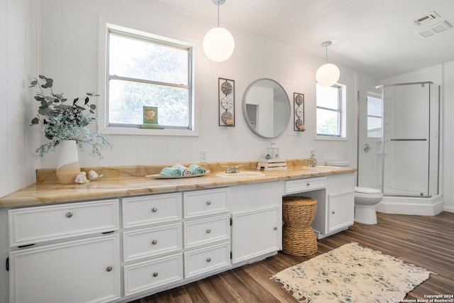 bathroom with visible vents, toilet, a stall shower, wood finished floors, and vanity