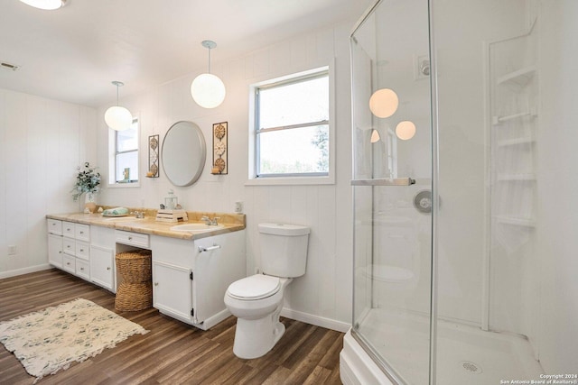 full bath featuring vanity, toilet, wood finished floors, and a stall shower