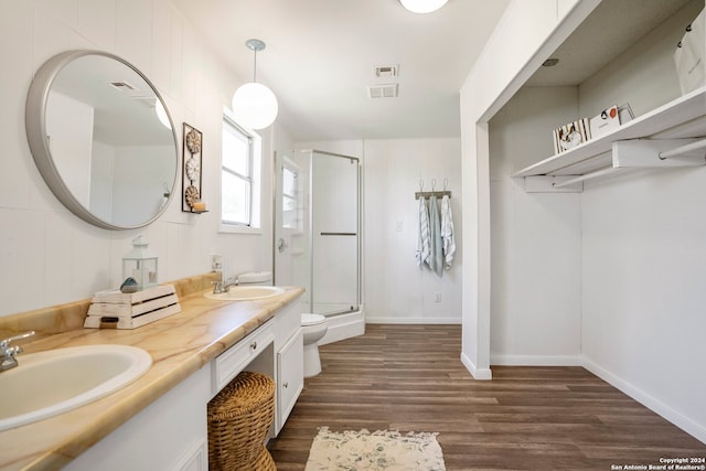 bathroom featuring hardwood / wood-style floors, toilet, walk in shower, and vanity