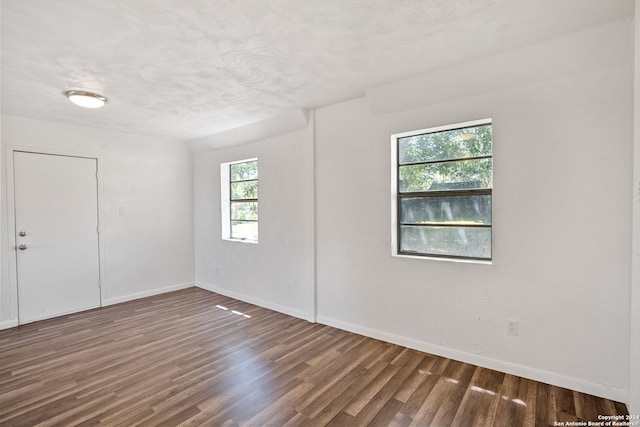 spare room with plenty of natural light and dark hardwood / wood-style flooring