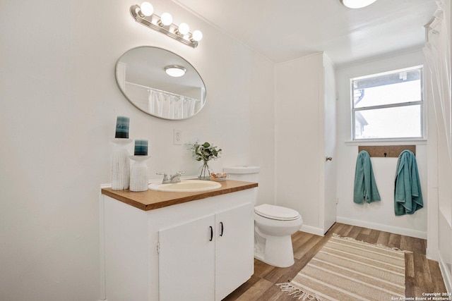 full bathroom with vanity, toilet, wood finished floors, and baseboards