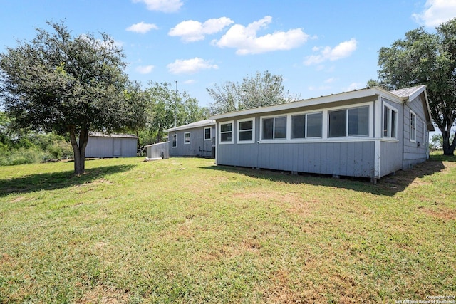 rear view of property featuring metal roof and a yard