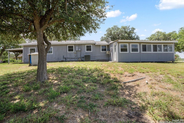 rear view of house with central air condition unit, a yard, and metal roof