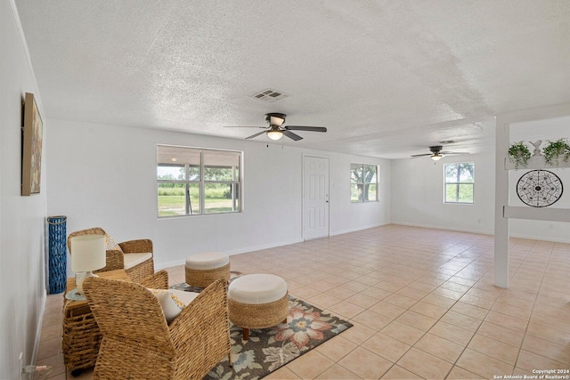 sitting room featuring visible vents, a textured ceiling, ceiling fan, and light tile patterned flooring