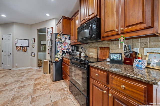 kitchen with light tile patterned flooring, backsplash, dark stone counters, and black appliances