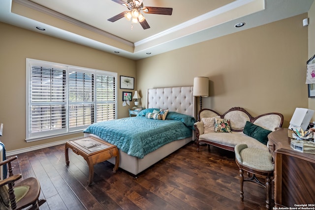 bedroom featuring ceiling fan, a tray ceiling, and wood-type flooring