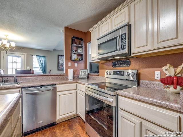 kitchen featuring stainless steel appliances, a chandelier, sink, a textured ceiling, and dark hardwood / wood-style flooring