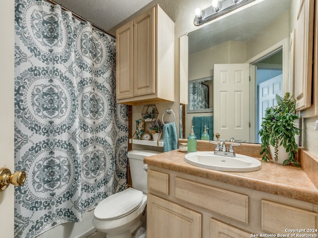 bathroom featuring a textured ceiling, toilet, and vanity