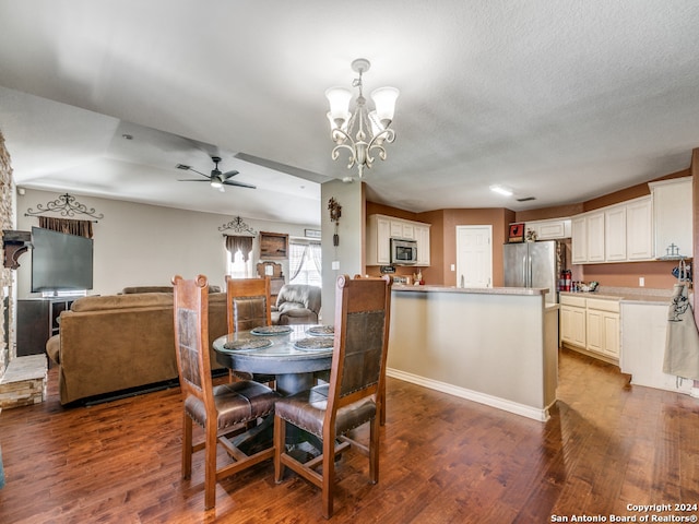 dining room with a textured ceiling, ceiling fan with notable chandelier, and hardwood / wood-style flooring