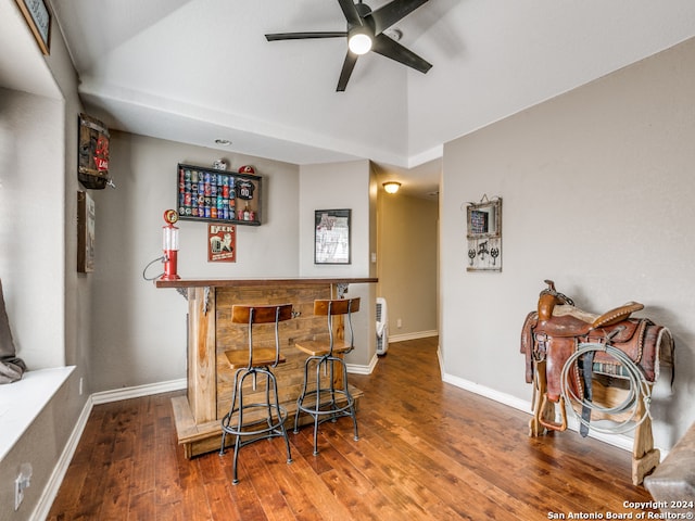 bar with ceiling fan and wood-type flooring