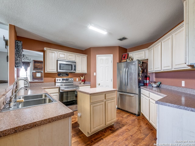 kitchen featuring appliances with stainless steel finishes, hardwood / wood-style floors, sink, a textured ceiling, and kitchen peninsula