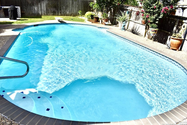 view of swimming pool with a fenced in pool, a fenced backyard, and a diving board