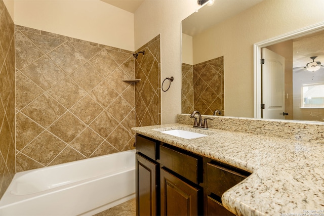 bathroom with tile patterned flooring, ceiling fan, tiled shower / bath combo, and vanity