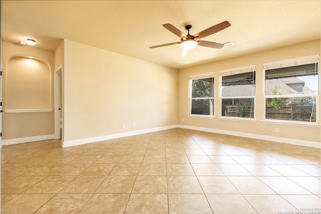 tiled spare room with ceiling fan and a healthy amount of sunlight