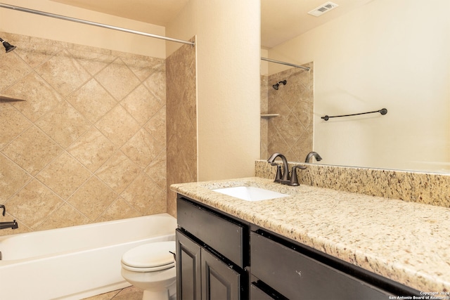 full bathroom with tile patterned flooring, vanity, tiled shower / bath combo, and toilet