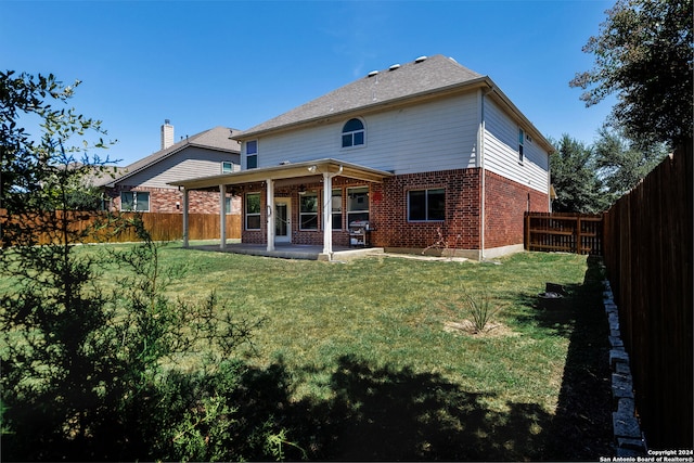 rear view of house featuring a patio area and a yard