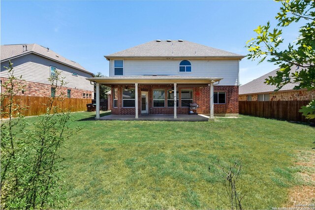 rear view of house with a patio and a yard