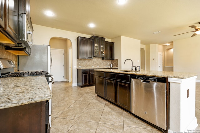 kitchen featuring backsplash, sink, a kitchen island with sink, ceiling fan, and stainless steel appliances