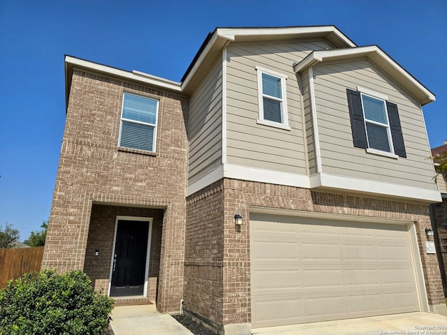 view of front of property with a garage, brick siding, and fence