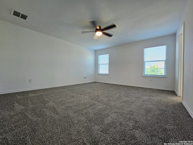 carpeted empty room featuring ceiling fan and plenty of natural light