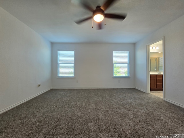 unfurnished bedroom with ceiling fan, carpet, and connected bathroom