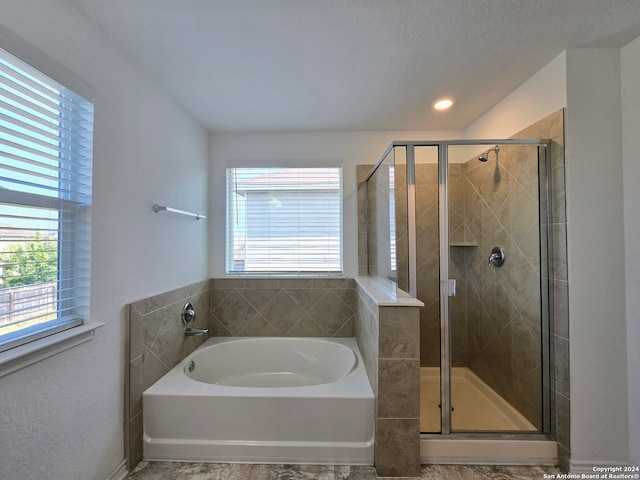 bathroom with tile patterned flooring, separate shower and tub, and a textured ceiling