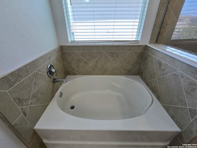 bathroom featuring a wealth of natural light and a tub