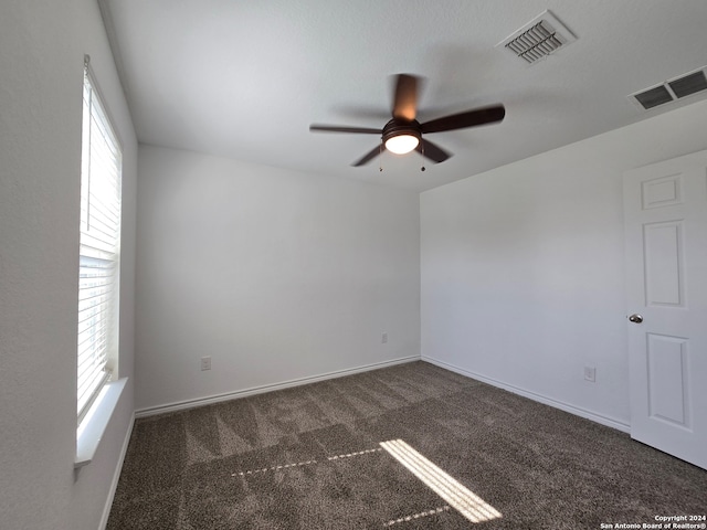 unfurnished room with ceiling fan and carpet