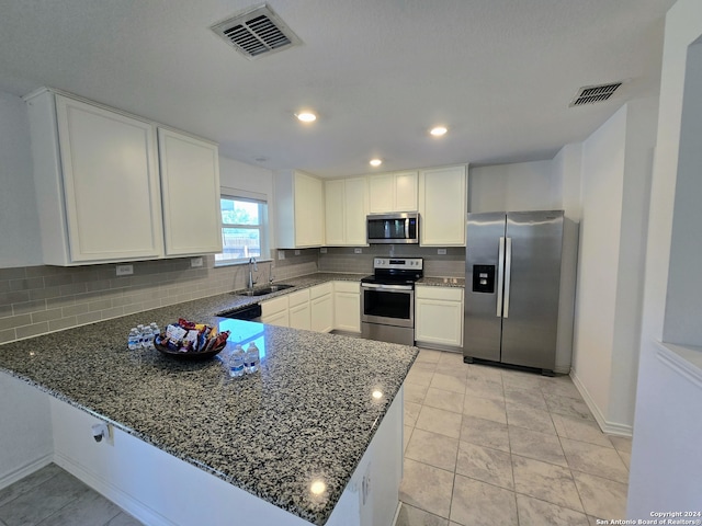 kitchen featuring light tile patterned flooring, appliances with stainless steel finishes, dark stone countertops, and backsplash