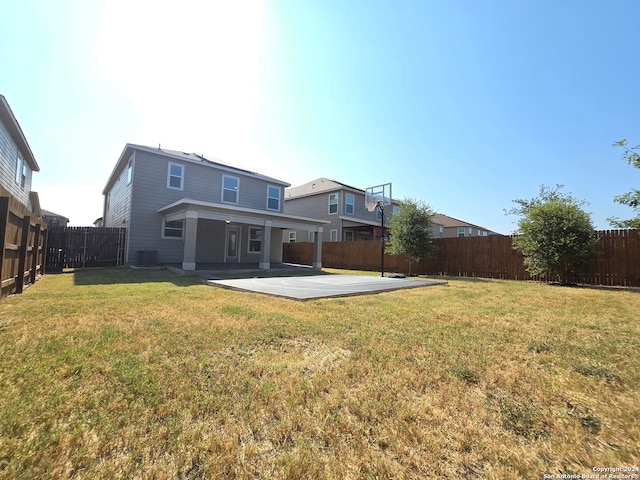 back of house featuring central AC unit, a patio, and a lawn