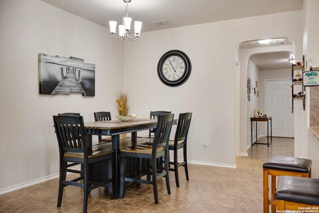 tiled dining area with an inviting chandelier